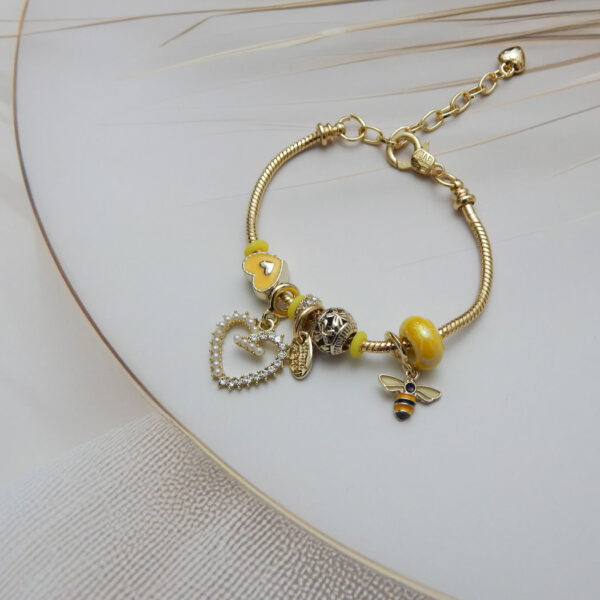 Yellow charm bracelet with bee pendant and pearl-crystal heart drop on gold chain