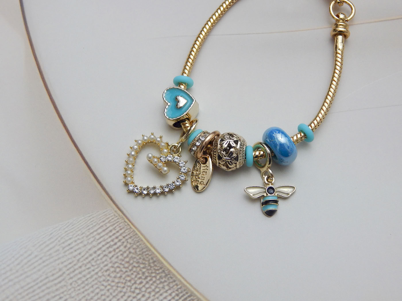 Blue Heart & Bee Charm Bracelet with enamel heart, bee pendant and aqua bead charms on adjustable gold snake chain