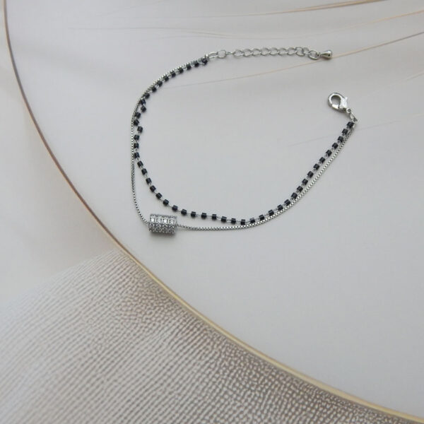 Dual layer bracelet with black beads and crystal barrel charm on silver chain