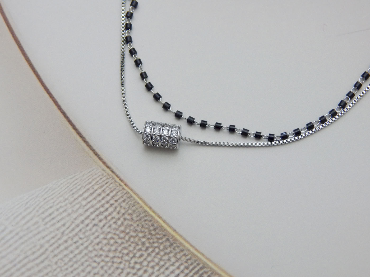 Dual layer bracelet with black beads and crystal barrel charm on silver chain