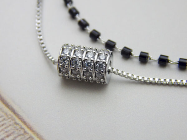 Dual layer bracelet with black beads and crystal barrel charm on silver chain