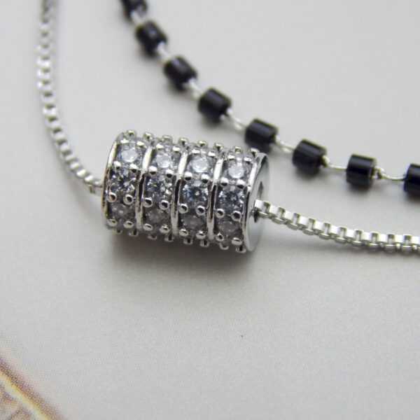 Dual layer bracelet with black beads and crystal barrel charm on silver chain