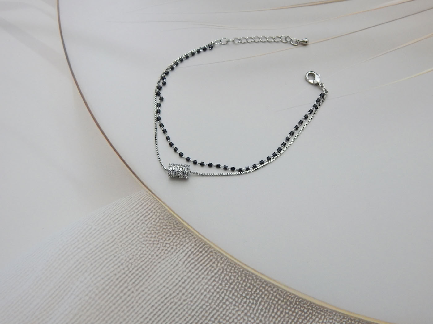 Dual layer bracelet with black beads and crystal barrel charm on silver chain