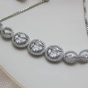 Illusion cluster bracelet in silver finish in zoom— seven oval halo stations with mixed stone clusters on box chain
