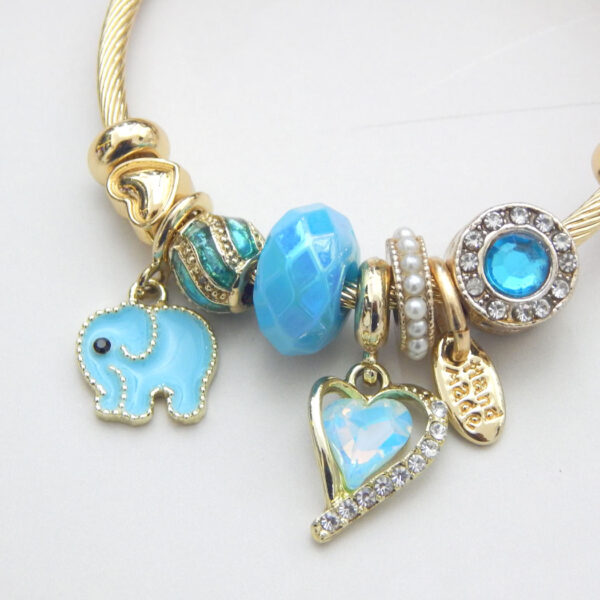 Gold charm bracelet with blue enamel elephant and heart charm