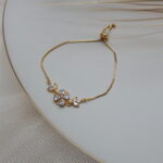 Gold-toned bracelet with white crystal floral design for women