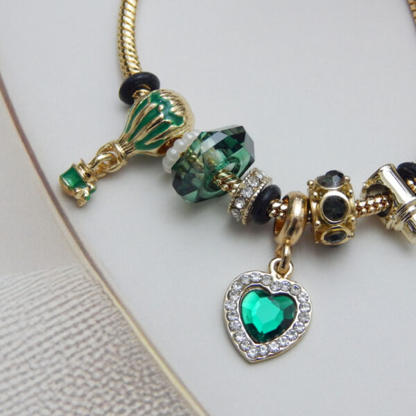 Bracelet featuring a green heart charm, glass balloon bead, Murano-style beads, and snake chain