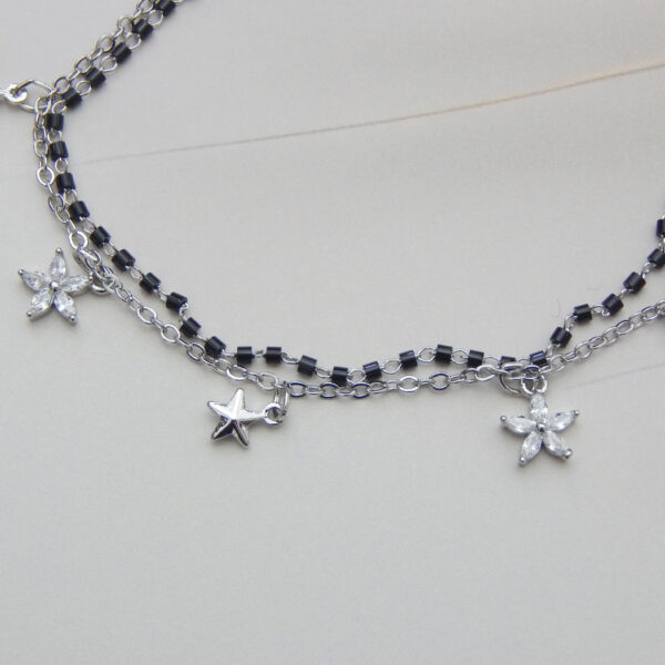 Silver dual chain bracelet with black beads, star and flower charms
