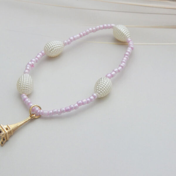 Light pink seed bead bracelet with pearl-look oval beads and Eiffel Tower charm