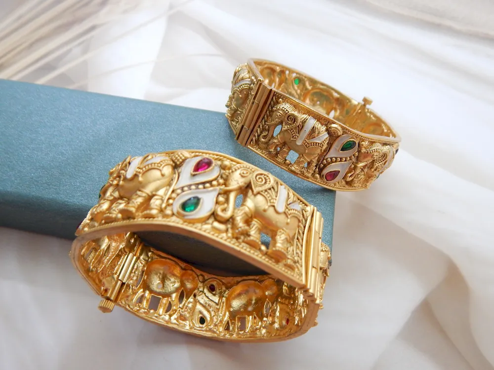 Elephant motif kada in antique gold plating with red, green, and white teardrop stones