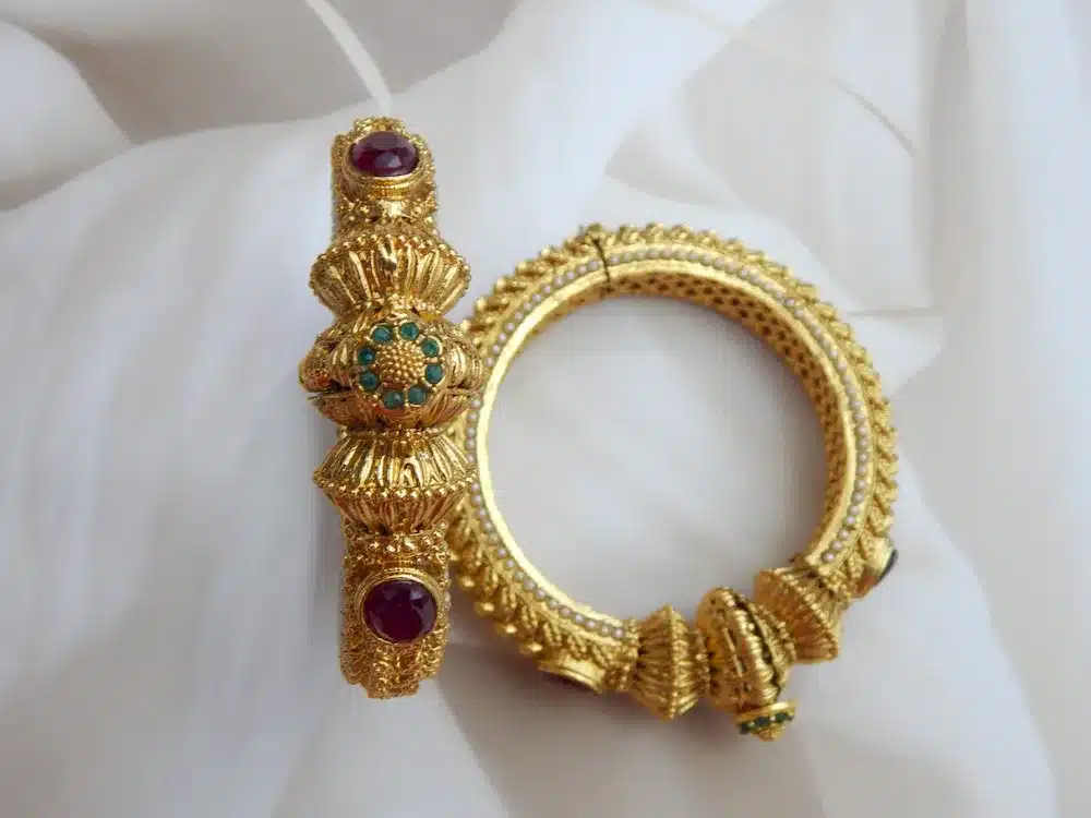 Antique gold-plated kada set with elephant and gemstone motifs on white background