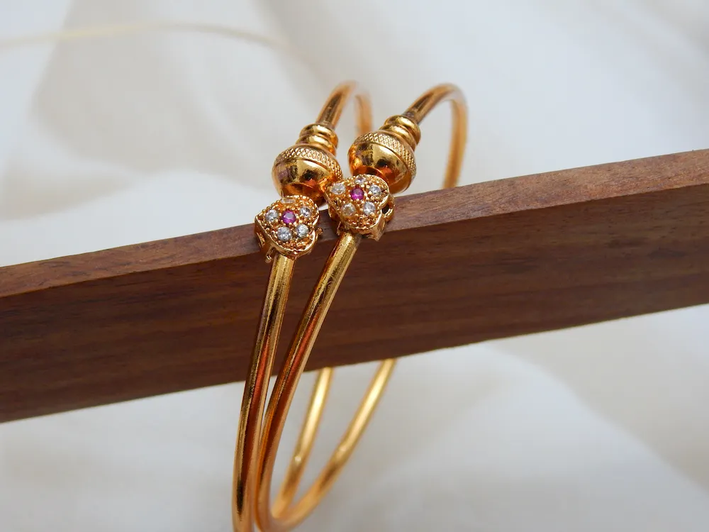 Gold-plated kada with heart-shaped stone charm and sparkling accents