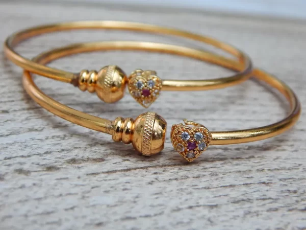 Gold-plated kada with heart-shaped stone charm and sparkling accents
