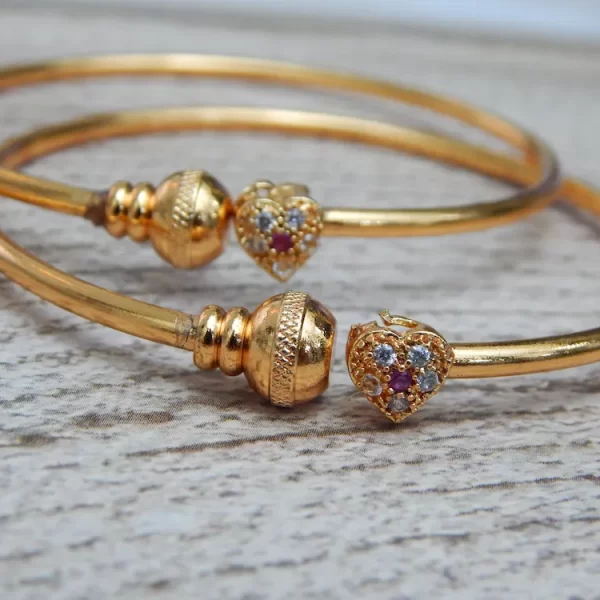 Gold-plated kada with heart-shaped stone charm and sparkling accents