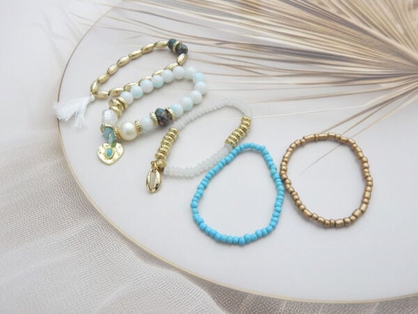 Bracelet set with gold, blue, and white beads featuring shell, tassel, and heart charms – stylish 5-piece ocean-inspired set under ₹299