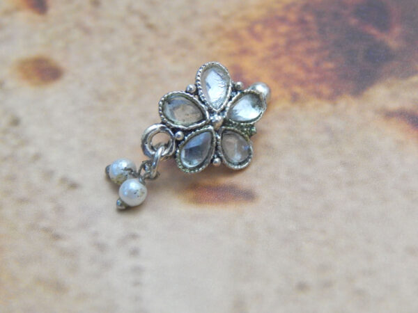 Oxidised five-petal stone nath with triple pearl drops on rustic background