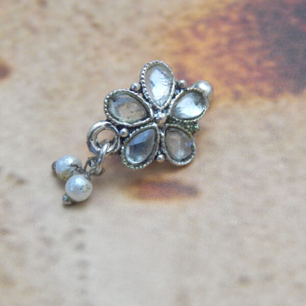 Oxidised five-petal stone nath with triple pearl drops on rustic background