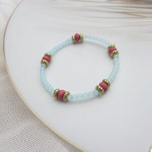Light blue beaded bracelet with coral-toned and gold accent spacers