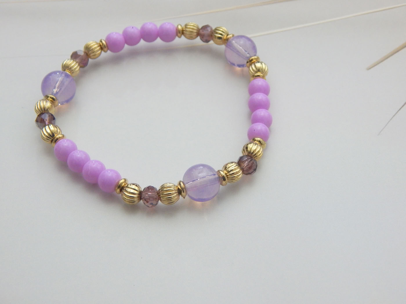Violet and pink bead bracelet with golden spacers and glossy finish