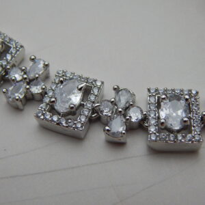 A stylish geometric necklace and earring set with alternating oval and square designs in a modern, silver-toned finish.