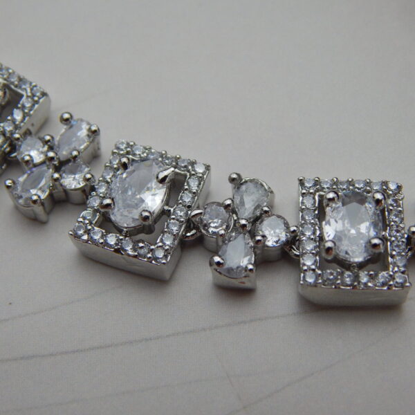 A stylish geometric necklace and earring set with alternating oval and square designs in a modern, silver-toned finish.