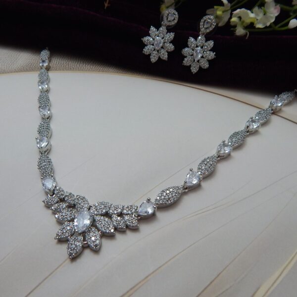 Close-up of Gul Bahar designer floral necklace and earring set in a silver tone finish with an intricate floral design