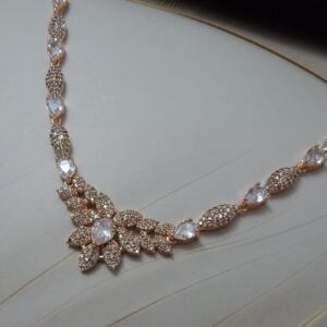 Close-up of Gul Bahar designer floral necklace and earring set in a rose gold finish with an intricate floral design
