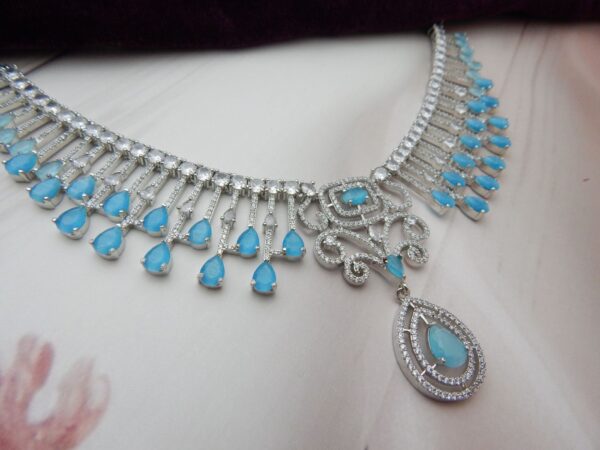 Turquoise blue american diamond fringe necklace with cascading teardrop drops and scrollwork centre