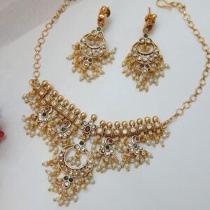 An antique matte gold choker necklace and earring set with a traditional design, featuring dangling pearls and red, green, and clear stones.