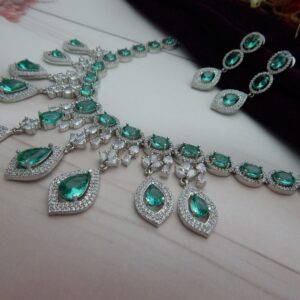 Close-up of the Noorjahan statement necklace and earring set featuring a cascade of green pendants and a silver finish.