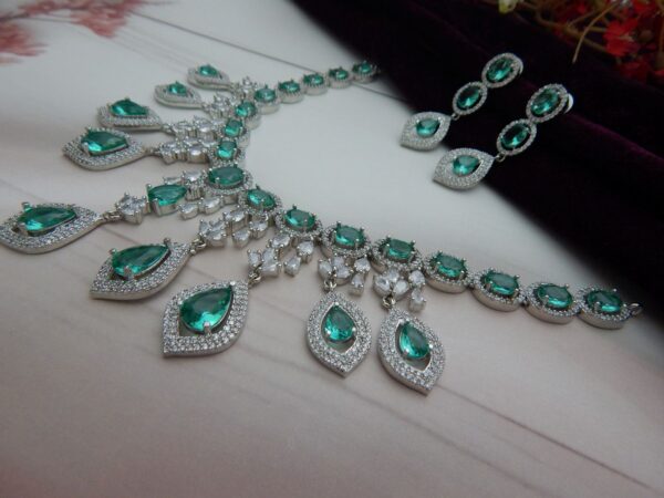 Close-up of the Noorjahan statement necklace and earring set featuring a cascade of green pendants and a silver finish.