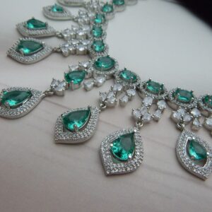 Close-up of the Noorjahan statement necklace and earring set featuring a cascade of green pendants and a silver finish.