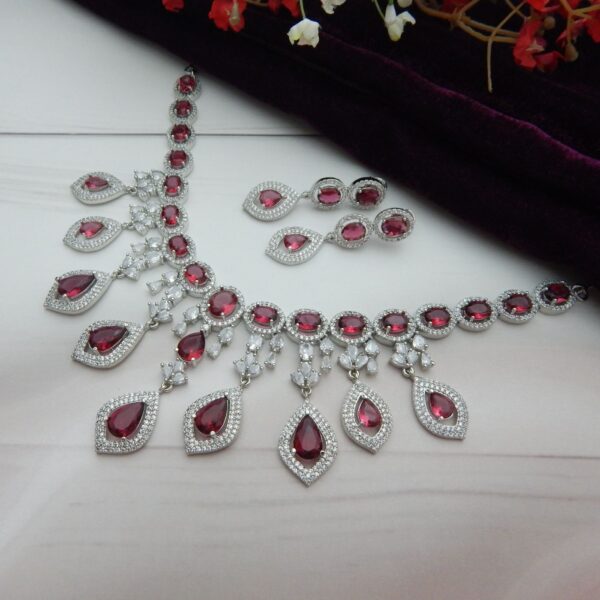 Close-up of the Noorjahan statement necklace and earring set featuring a cascade of red pendants and a silver finish.