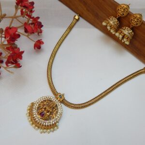 A traditional temple jewelry short necklace with a snake chain and a round goddess pendant with cubic zirconia stones and a single pearl drop.