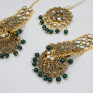 A Kundan maang tikka and matching earrings set with large fan-shaped pendants and dark green beaded drops.