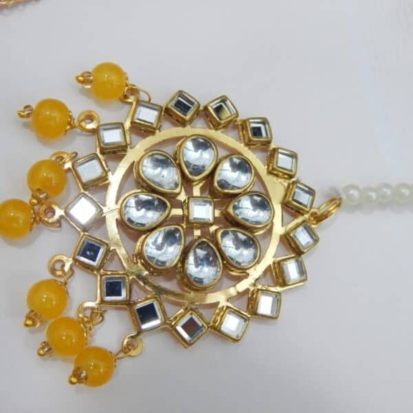 Navratri Yellow Jewellery - Royal Reflection DS A Kundan maang tikka and matching earrings set with large fan-shaped pendants and yellow beaded drops.
