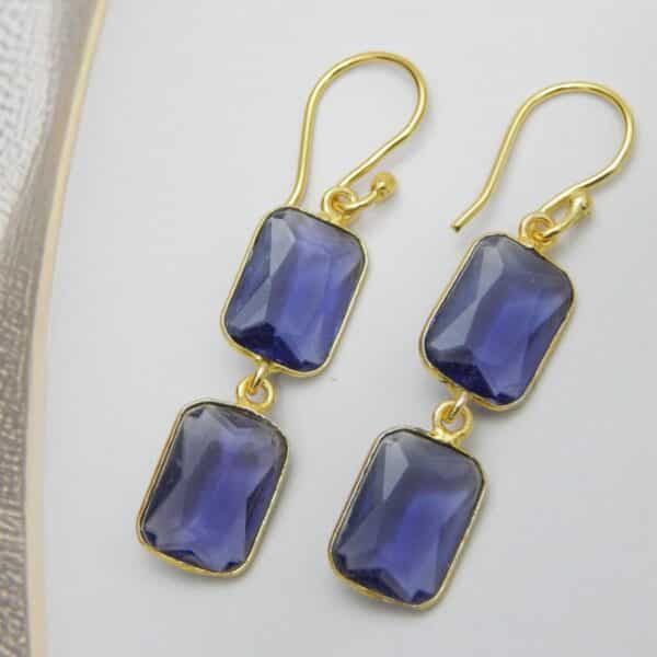 Gold-tone dangle earrings with two rectangular, faceted violet colored stones stacked vertically.
