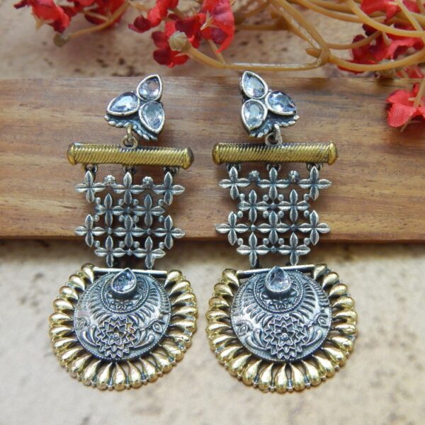 A pair of large, dual-tone oxidized silver and gold earrings with jaali lattice work and a scalloped medallion dangle.