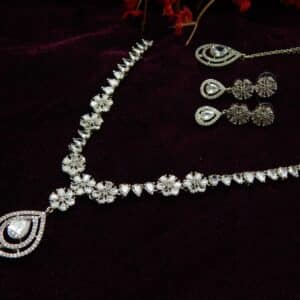 Silver-tone AD/CZ floral pattern necklace set with matching teardrop earrings and a maang tikka.