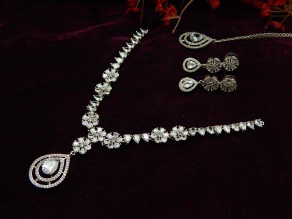 Silver-tone AD/CZ floral pattern necklace set with matching teardrop earrings and a maang tikka.