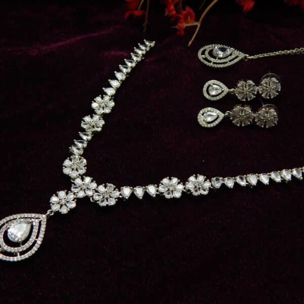 Silver-tone AD/CZ floral pattern necklace set with matching teardrop earrings and a maang tikka.
