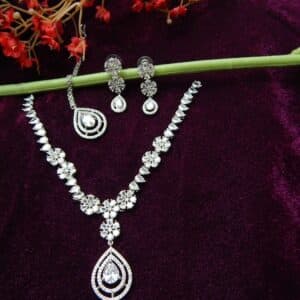 Silver-tone AD/CZ floral pattern necklace set with matching teardrop earrings and a maang tikka.