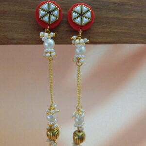 A pair of long, traditional red and gold-toned earrings with a geometric stud, hanging pearl drops, and a ribbed gold bead.