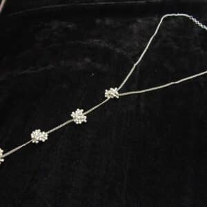 Delicate silver tone Y-shaped lariat necklace with floral bead clusters descending along the drop.