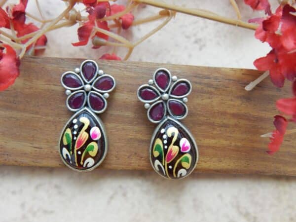 Floral stud and a teardrop dangle in maroon.
