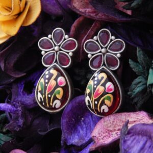 Floral stud and a teardrop dangle in maroon.