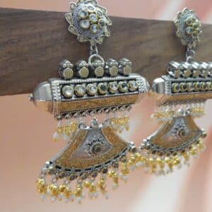 A pair of oxidised and gold-toned fusion jhumka earrings with a half-moon design and pearl drops.