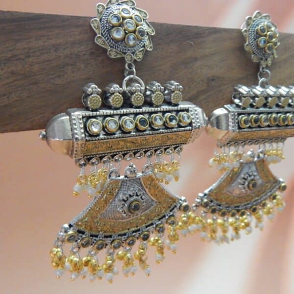 A pair of oxidised and gold-toned fusion jhumka earrings with a half-moon design and pearl drops.