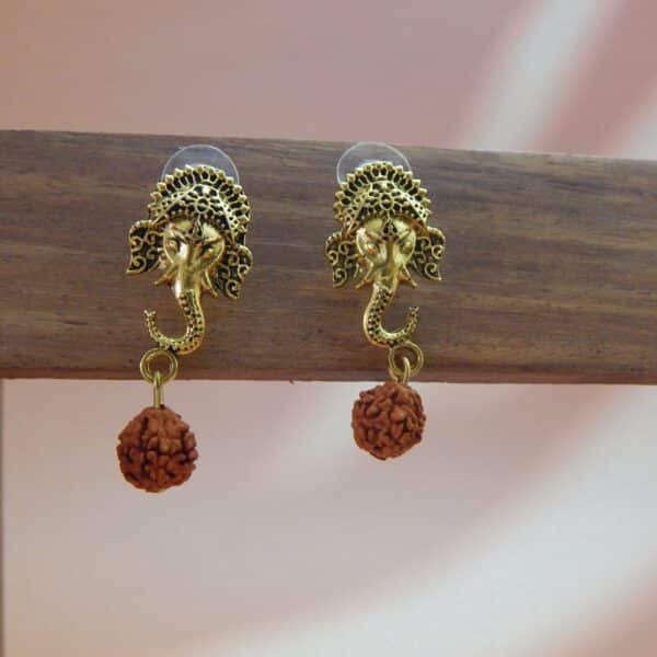 A pair of antique gold-toned earrings featuring an intricate Ganesha stud with a single rudraksha bead hanging below.