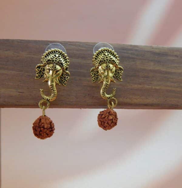 A pair of antique gold-toned earrings featuring an intricate Ganesha stud with a single rudraksha bead hanging below.